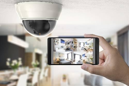 mão a segurar smartphone com acesso vídeos de camara de videovigilancia